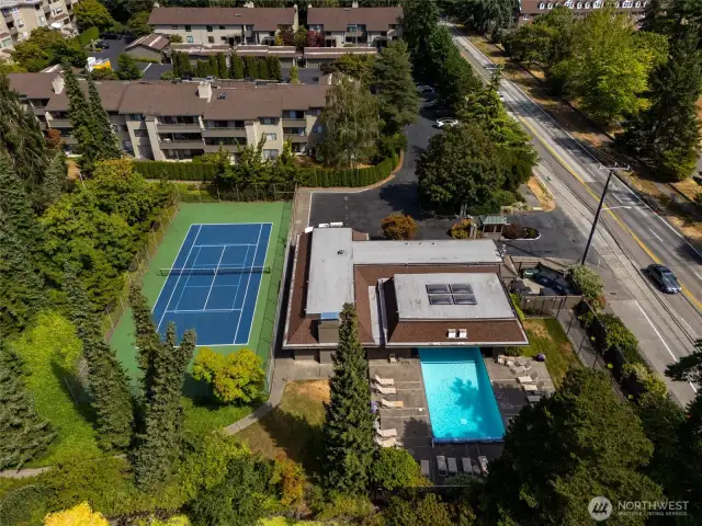 Aerial view of the Parkpoint clubhouse, pool, hot tub and tennis court.  The clubhouse has a exercise/game room, locker rooms and saunas.