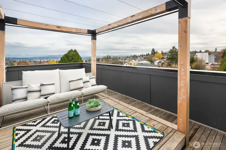 Thoughtful design meets breathtaking scenery on the rooftop level, where custom seating, warm wood surfaces and open-air coverage showcase uninterrupted views.