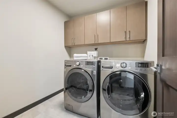 We love the laundry room upstairs, where the bedrooms are! Lots of room with built-in cabinets, room for additional wall storage to the left and the LG frontload washer & dryer stay!