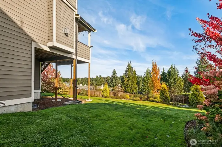 Large lawn and mature landscaping with a beautiful backdrop of the amazing evergreens in the Meridian Valley Country Club!