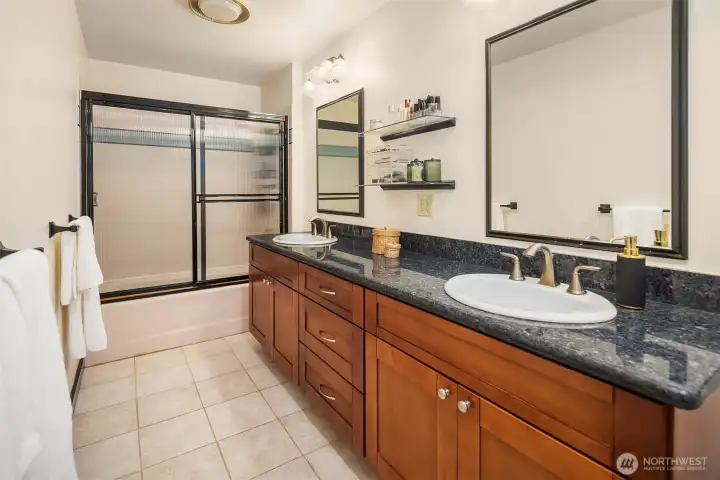 A rare combination of dual vanities and extra space for a mid-century primary bathroom