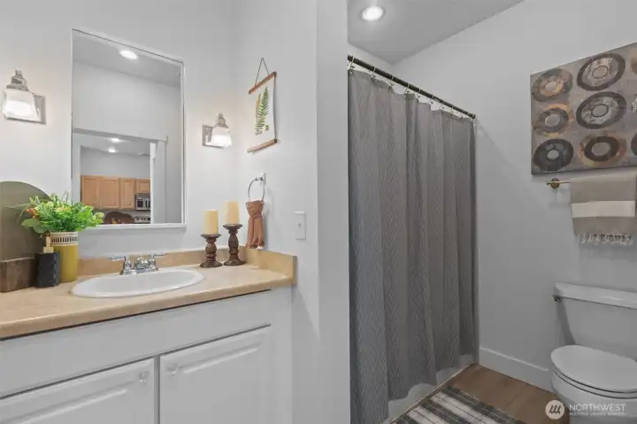 LVP floors extend into the bathroom for a clean seamless look