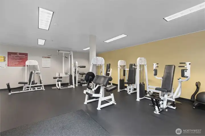 Fitness center is equipped with several machines, cardio equipment, and plenty of space to move