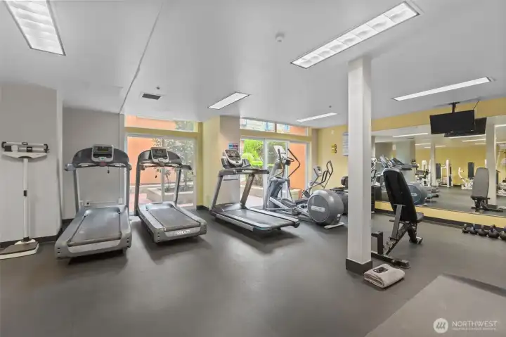 Fitness center is equipped with several machines, cardio equipment, and plenty of space to move