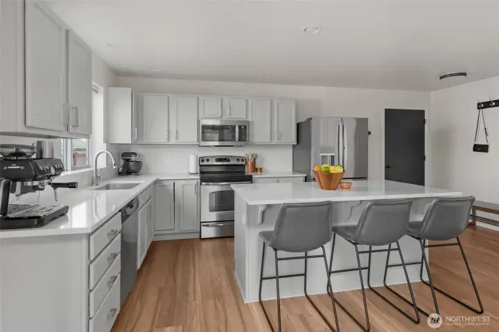 Modern kitchen with quartz countertops and stainless steal appliances with door garage.