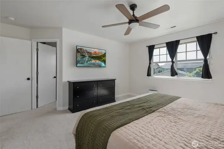 Spacious primary bedroom with ceiling fan.
