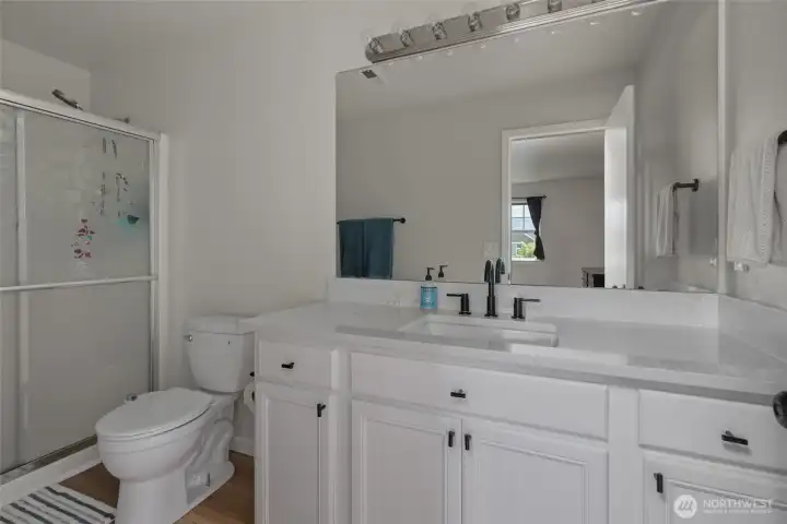 Primary bathroom with quartz countertops.