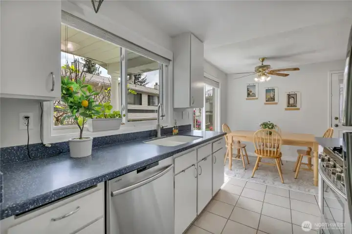 Light filled kitchen and eating area overlooking colorful garden spaces.