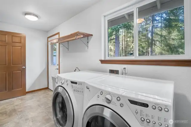 Washer and dryer included in spacious laundry room with exterior door leading out to private deck.