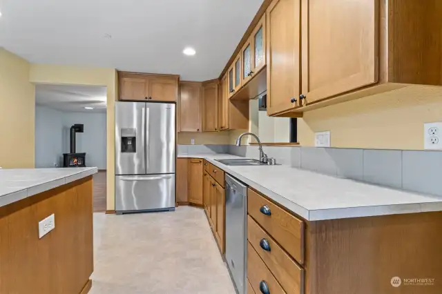 Tile back splash. Vinyl flooring. Double kitchen sink (stainless) with gooseneck faucet.