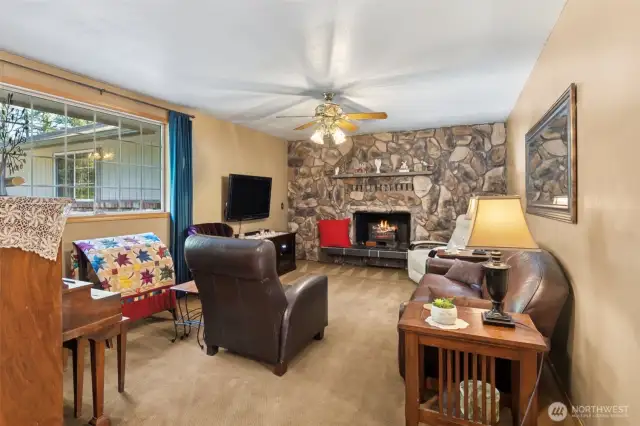Gather in style - living room with a beautiful river rock fireplace.