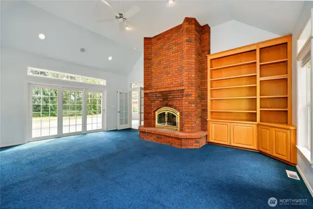 The wonderful family room has sliding doors onto the deck, a wood-burning fireplace, and lovely built-ins