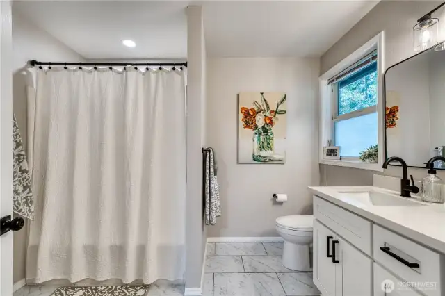 Primary bath with tub/shower unit leading to large walk-in closet on left.