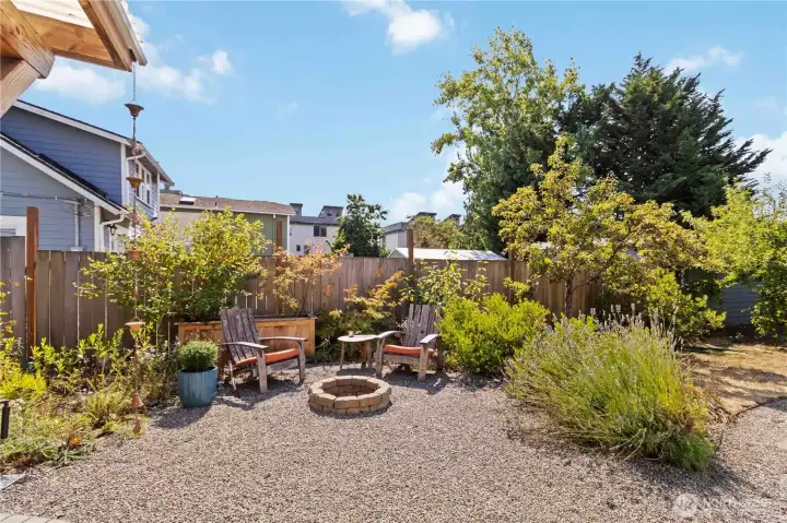 This backyard soace offers a cozy fire pit and  seating area