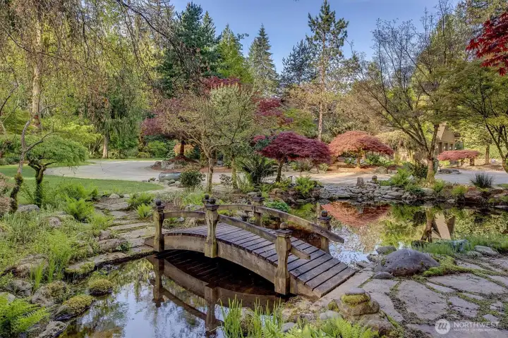 A beautiful pond with wooden bridge greets you at the circular drive