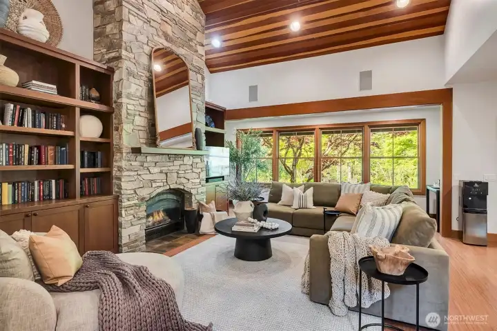 A two story stone fireplace in the living room with built-in bookcases. clear cedar vaulted ceilings, all oriented to the river views
