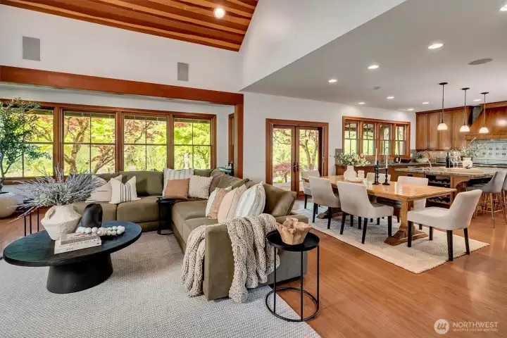 Living room open to the dining room, and eat-in kitchen, with walls of windows to the patio and Pilchuck Creek beyond