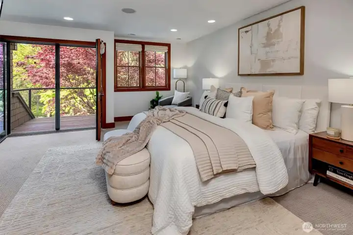 Primary bedroom on the upper level with a private deck. Listen to the river as you drift off to sleep