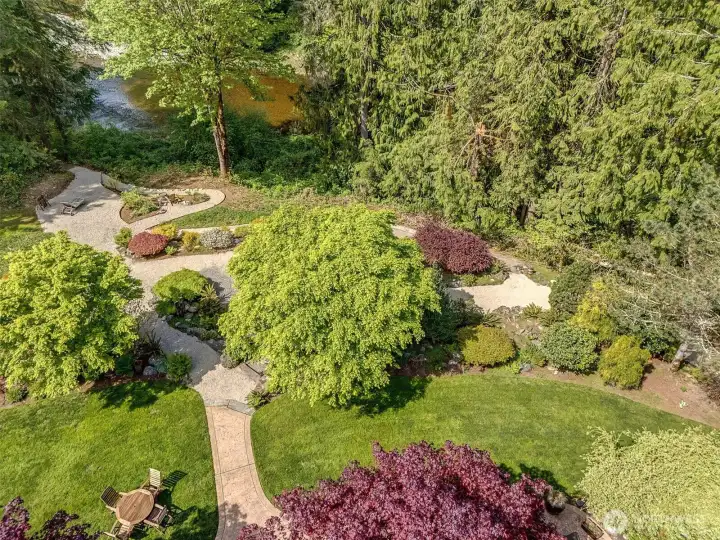 An aerial view of the grounds at the rear of the home, taking in the patio, and walkways to Pilchuck Creek