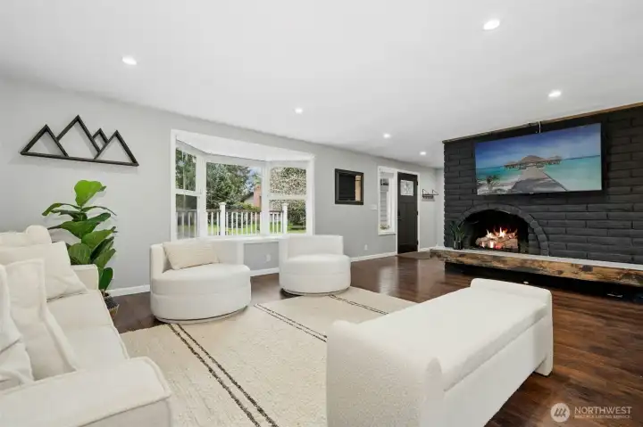 Refined living space with gas fireplace and sunlit bay window.