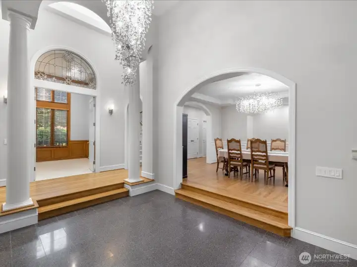 Brilliant chandelier hangs high above in HUGE vaulted ceiling.  Formal and beautiful dining room to the right with new and gorgeous chandelier.  The den/office is to the left and Primary bedroom is to the left of den.