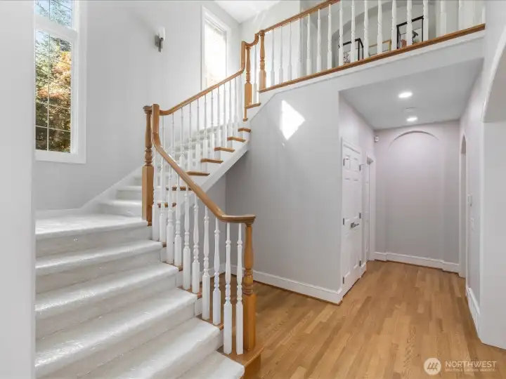 Elegant stairway leads upstairs to 3 bedrooms and 2 bathrooms.  Main floor 1/2 bath is down this hall to the left with the kitchen to the right.