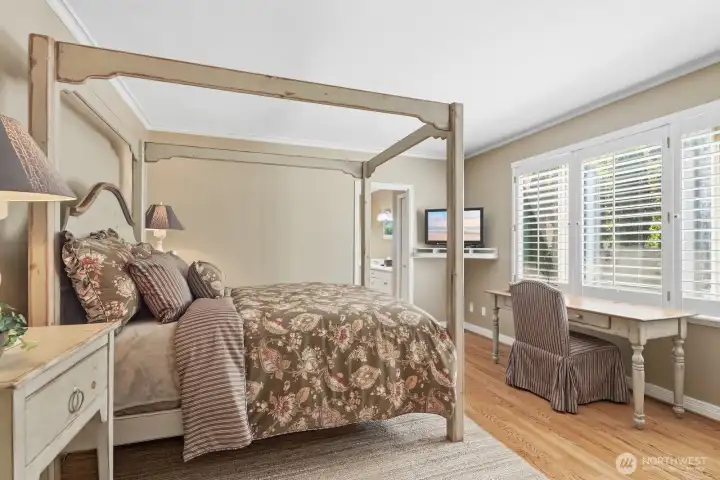 The main floor primary suite offers comfort and convenience, with hardwood floors and direct access to en suite bath and walk- closet.