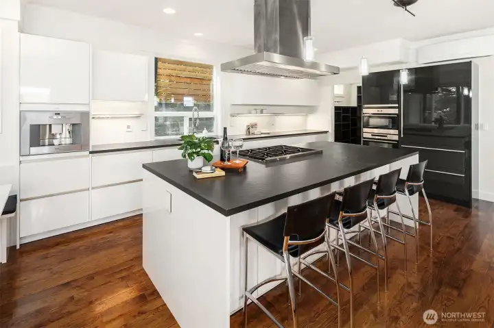 The large kitchen island holds a 6-burner gas range, ample storage, and bar seating The large kitchen island holds a 6-burner gas range, ample storage, and bar seating