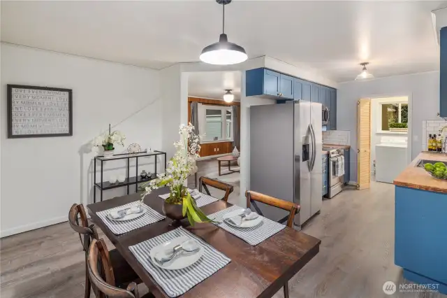 A view catching the entry to the living room and kitchen, from the dining room space.