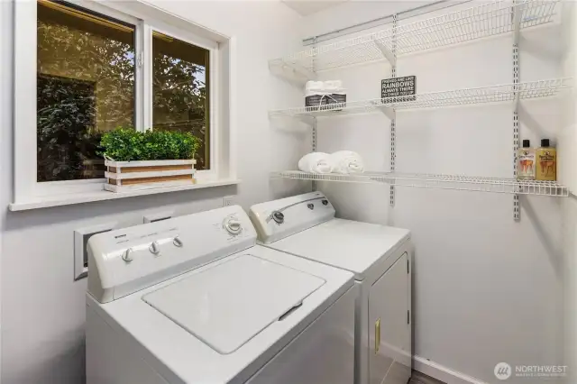 The laundry room is located at the end of the kitchen, through the louvered doors.