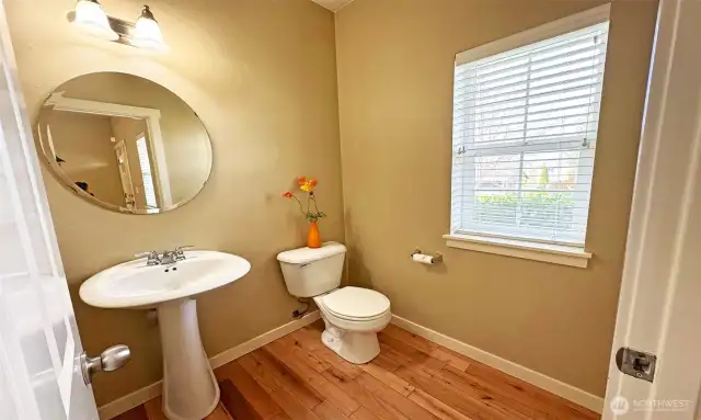Elegant Powder Room with pedestal vanity on main floor, and a window for great ventilation!