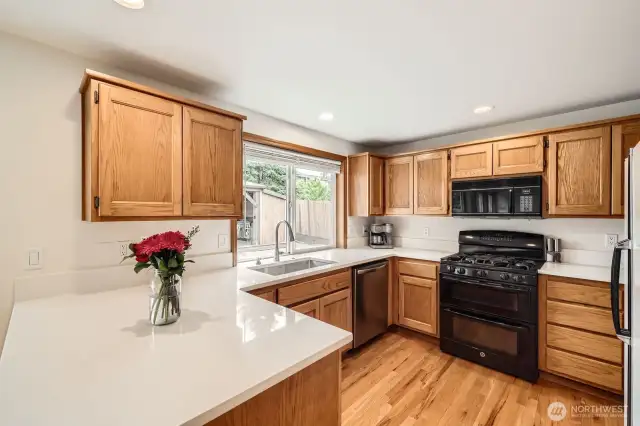 TASTEFUL KITCHEN WITH QUARTZ COUNTERS, PLENTY OF CABINET SPACE & EASE OF ACCESS TO DINING RM.