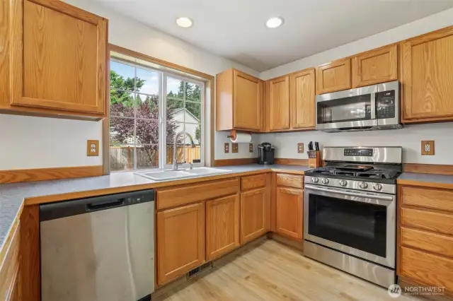 Kitchen with stainless steel appliances and new Luxury plank flooring.