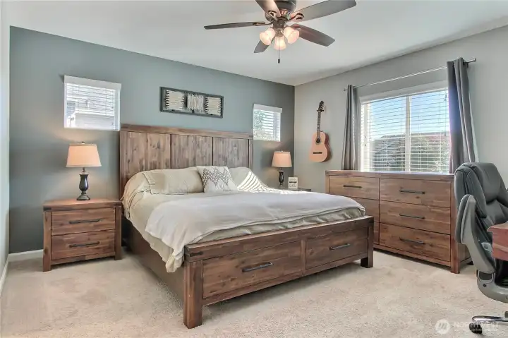 Primary suite view one, generous in size, convenient ceiling fan and plenty of windows.