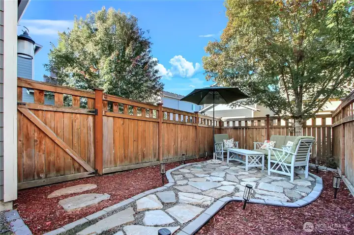 View of your side yard with recently upgraded and expanded sitting area with beautiful stone.