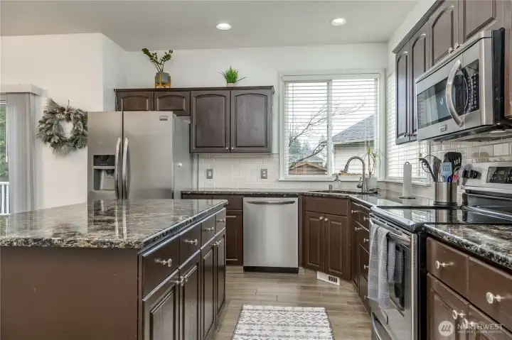 Great kitchen layout with granite counters, tiled backsplash, stainless appliances