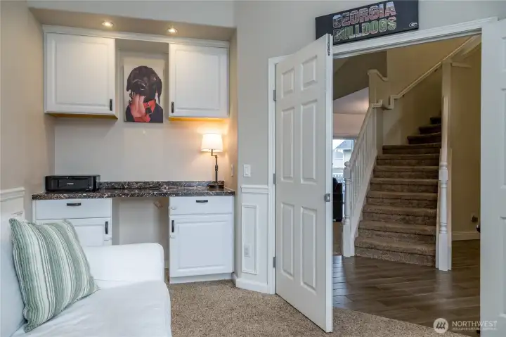 Office/playroom includes built-in desk and cabinetry, double-door entry