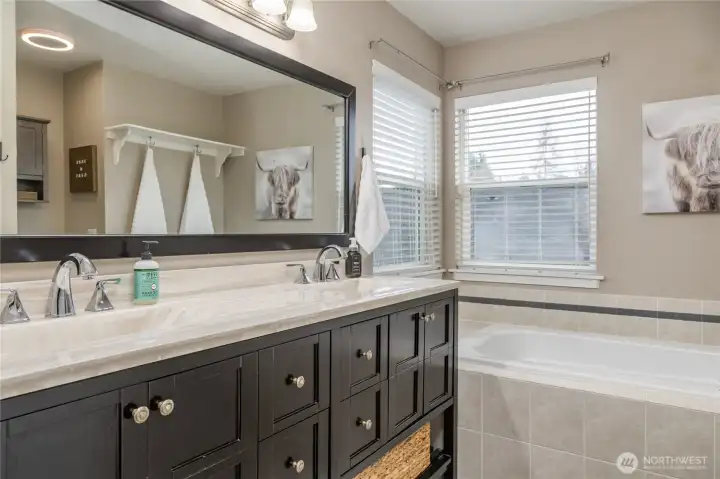 Double sinks and luxurious soaking tub in the primary bathroom