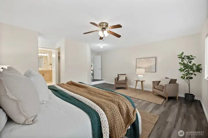 Primary bedroom looking out toward en-suite bathroom and closet to the left and room entrance beyond. Large enough for a cozy sitting area for reading and extra unwinding away from the rest of the house.