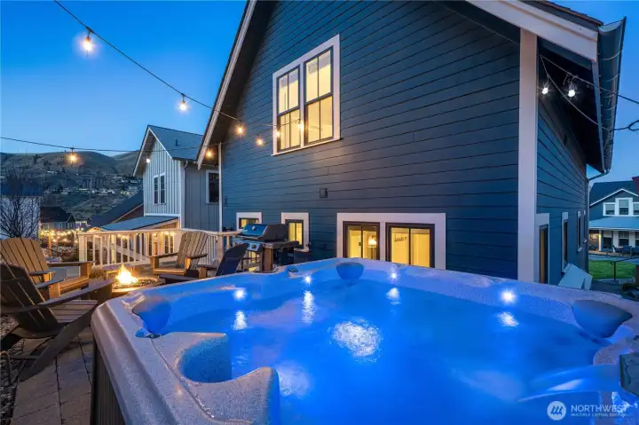 Twilight view of outdoor living area and private hot tub,