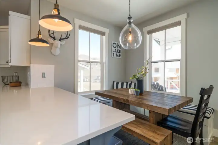 View of dining room with built in bench and decorative lighting.