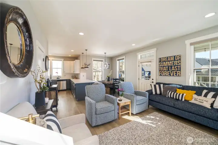 View 1 of Living Room with gas fireplace, looking towards the kitchen and dining room with built-in bench.