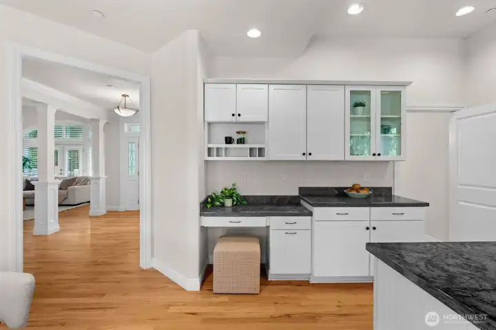 Built-in workspace and additional cabinetry provide functional storage and flexible everyday use adjacent to the kitchen.