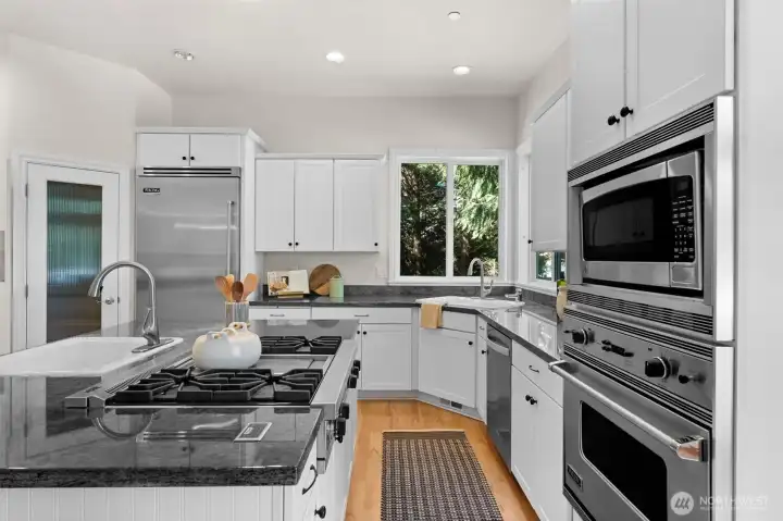 Kitchen with stainless steel appliances, center island cooktop, and ample counter space for everyday living and entertaining.