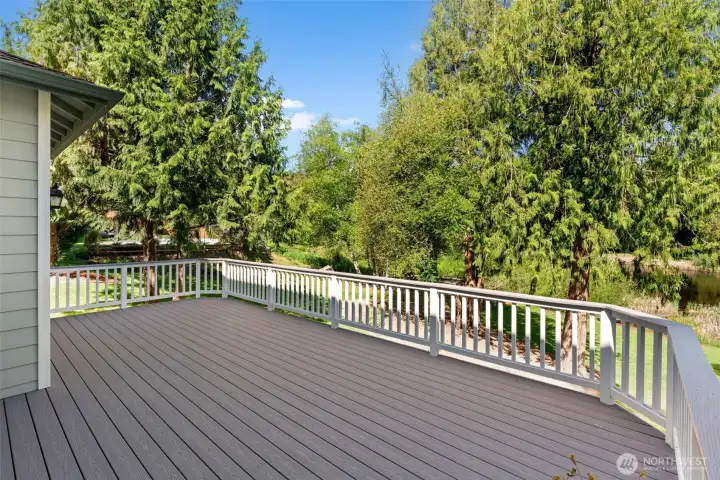 Expansive deck overlooking the surrounding greenery, offering a welcoming space for outdoor dining and relaxation.