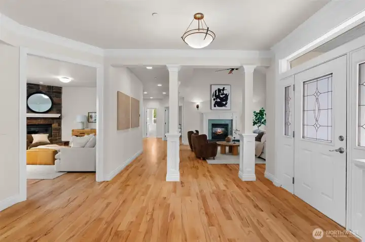 Welcoming entry with detailed millwork, hardwood floors, and open sightlines into the main living areas.