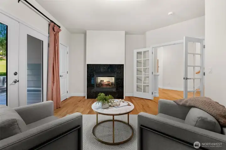 Room features a fireplace, deck access, and French doors connecting to the surrounding living spaces.