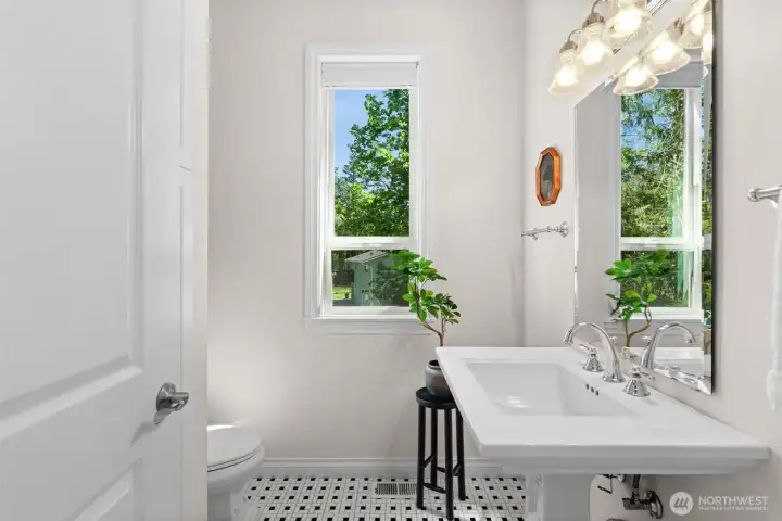 Convenient main level bath with pedestal sink, tile flooring, and natural outdoor outlooks.