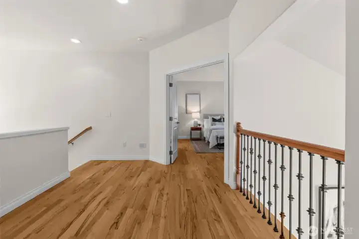 Upper level landing connects to surrounding bedrooms and overlooks the stairway below.