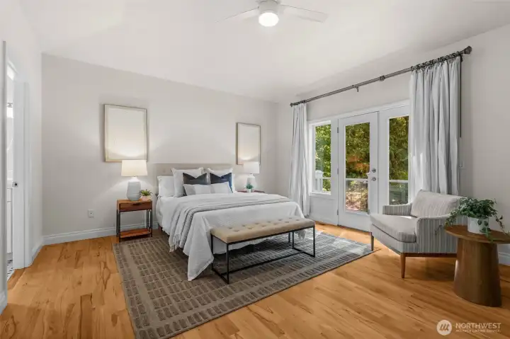 Primary bedroom features vaulted ceilings, hardwood flooring, and French doors leading to a private outdoor space.